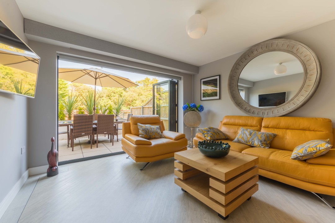 Living room with bi-folds that open to the outside dining area - High Tide