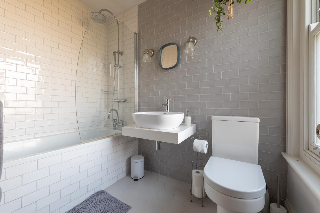 bathroom with rain shower over bath, basin and wc - Fig Tree Cottage