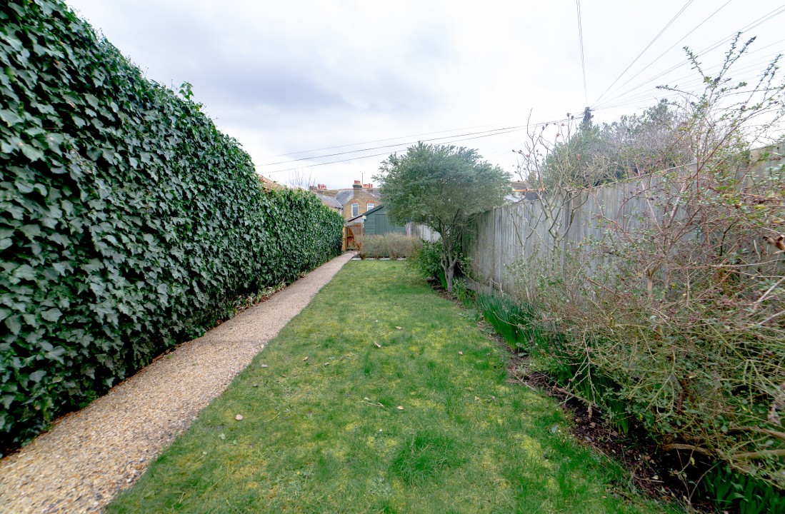 fenced garden with grass and seating area
