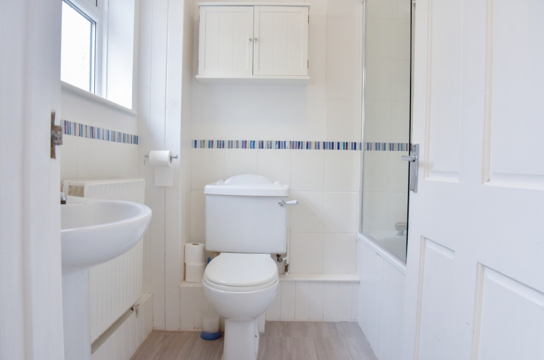ground floor bathroom with toilet, basin and shower over bath